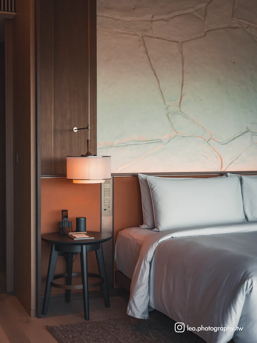 Deluxe Suite 的床頭飾板,以大阪城城牆的紋理為靈感,暖燈打上就像一面浮雕。