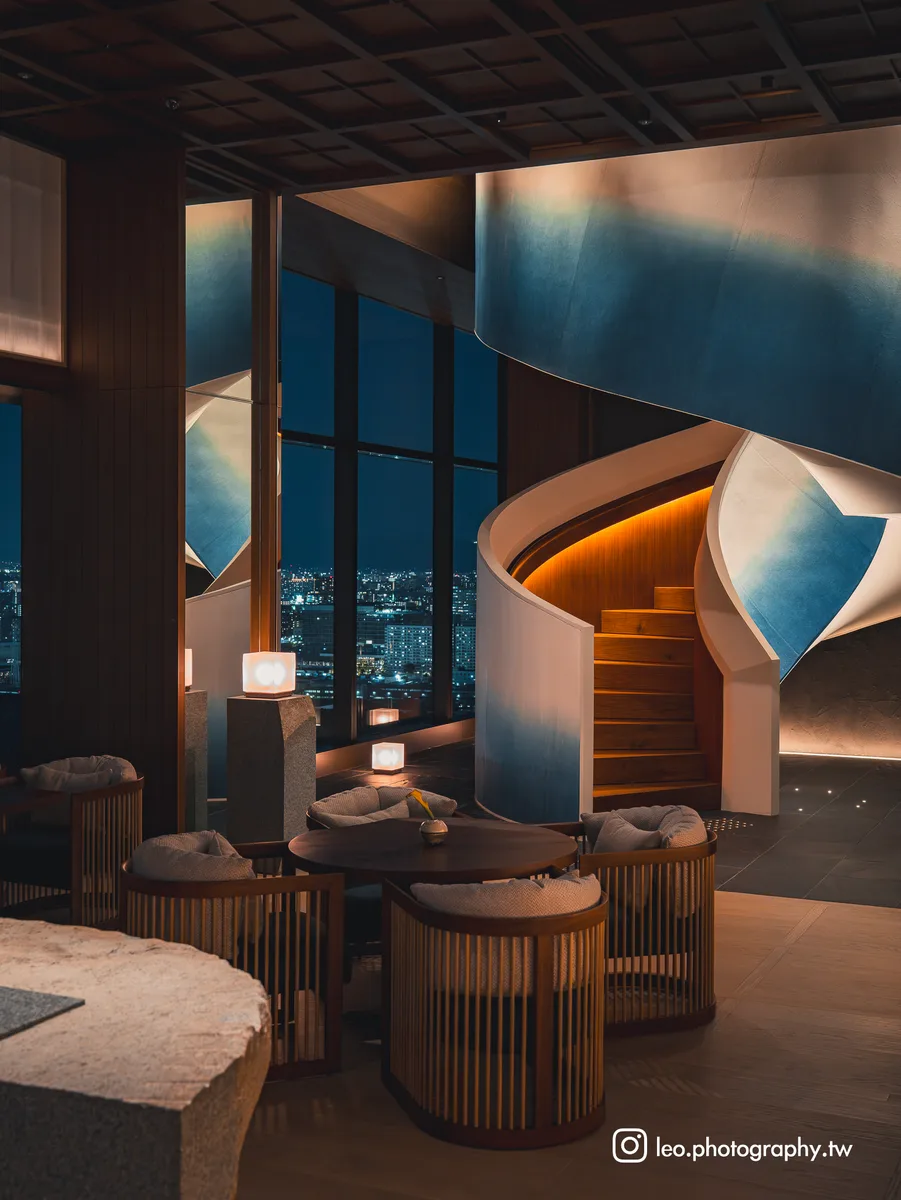 螺旋梯襯著窗外的大阪夜景。
